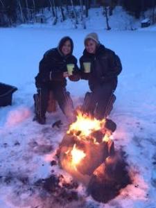 Sandy and Lesa relaxing by a fire on the ice.